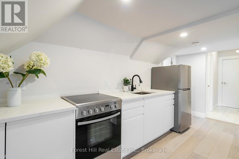 A modern kitchen with white cabinets and stainless steel appliances.