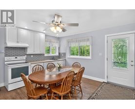 A kitchen with a table and chairs in front of a window.