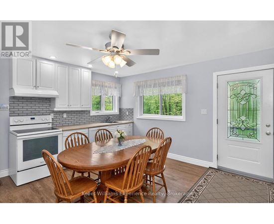 A kitchen with a table and chairs in front of a window.