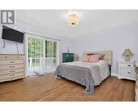 A bedroom with a bed, nightstand, and a television.