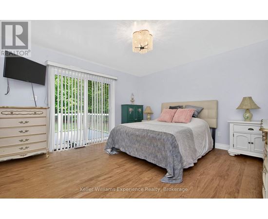 A bedroom with a bed, nightstand, and a television.