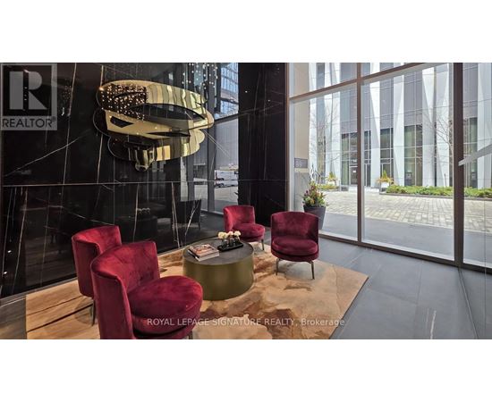 A modern living room with a glass table and red chairs.