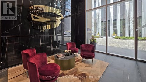 A modern living room with a glass table and red chairs.