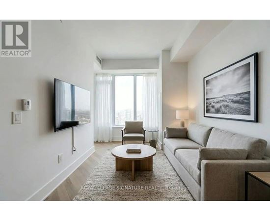 A living room with a couch, chair, and television.