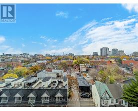 A view of a city from a high vantage point with buildings and trees.