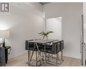 A modern dining room with a glass table and chairs.