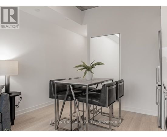 A modern dining room with a glass table and chairs.