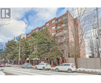 A red brick building with cars parked in front.