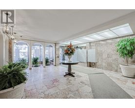 A real estate brokerage office with a large marble floor and a chandelier.