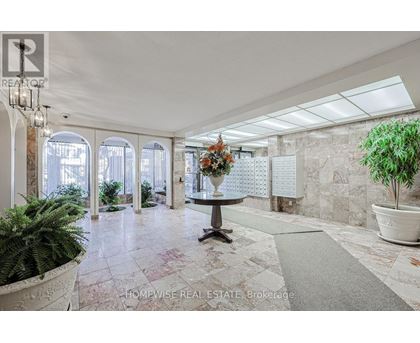 A real estate brokerage office with a large marble floor and a chandelier.