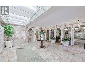 A spacious room with marble flooring and a row of arched windows.