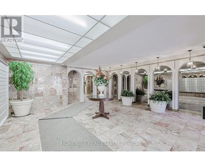 A spacious room with marble flooring and a row of arched windows.