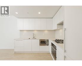 A white kitchen with a sink, oven, and stove.