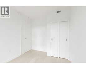 A white room with a door on the left and a white door on the right.