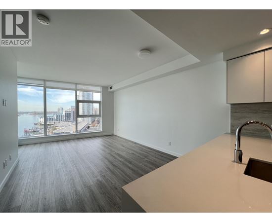 A modern kitchen with a large window overlooking the city.