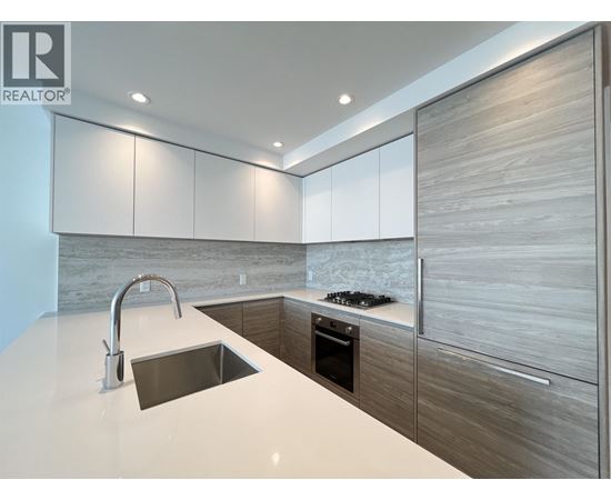 A modern kitchen with a sink and a stove top.