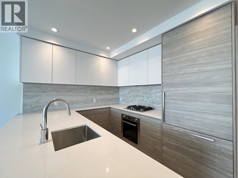 A modern kitchen with a sink and a stove top.