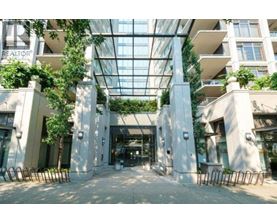 A glass ceiling with plants hanging from it and a building with a sign that says REALTOR.