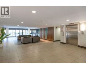 A spacious lobby area with a reception desk and a potted plant.