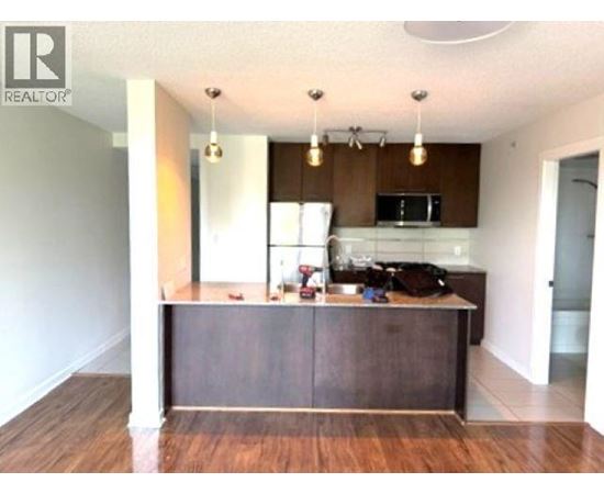 A kitchen with a wooden island and a microwave above it.