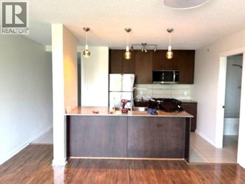 A kitchen with a wooden island and a microwave above it.