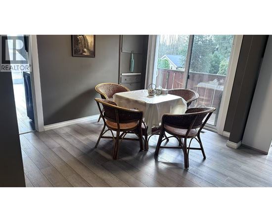 A dining room with a table and chairs.