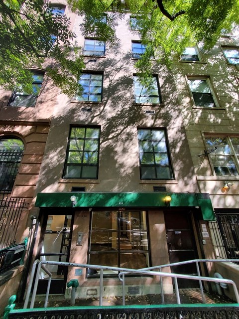 A building with a green awning and a metal staircase.