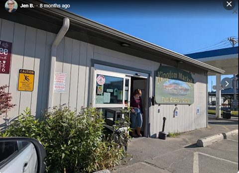 A woman is entering a Kingdom Market store.