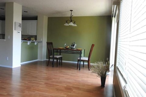 A dining room with a table and chairs.