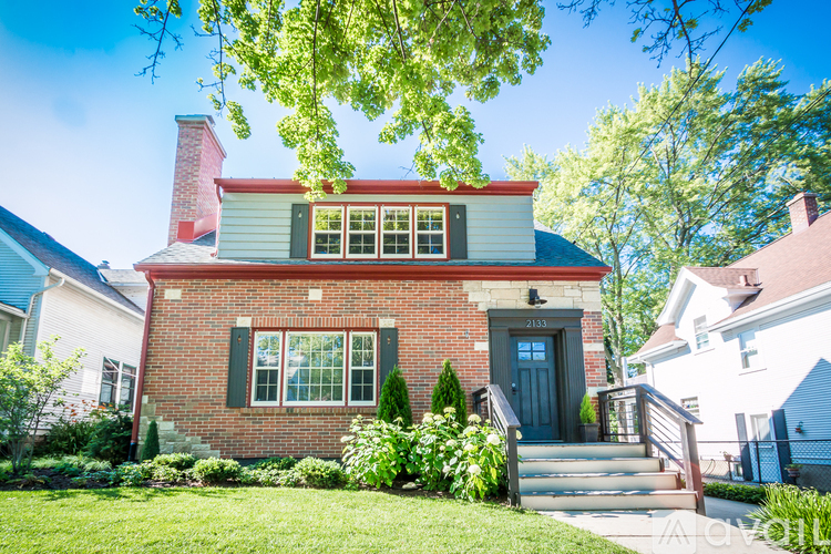 A red brick house with a black door and windows.
