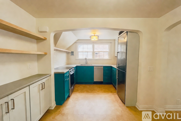 A kitchen with teal cabinets and a window.
