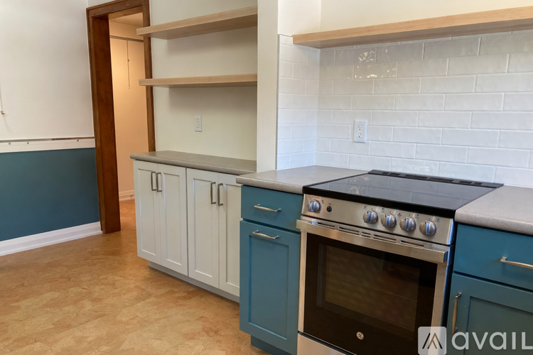 A kitchen with a stove top oven and cabinets.