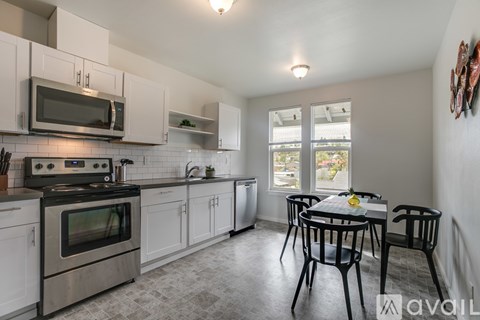 A kitchen with white cabinets and a black stove top oven.