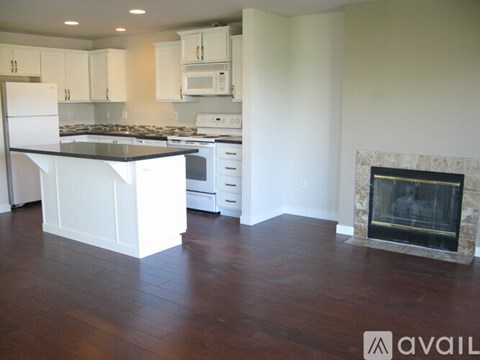 A kitchen with white cabinets and a black countertop.