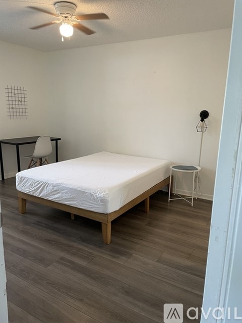 A bedroom with a bed, chair, and a small table.