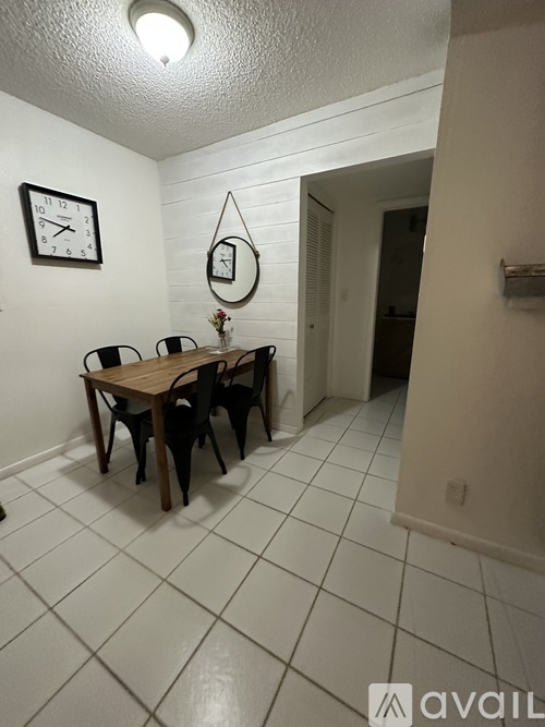 A dining room with a table and chairs.