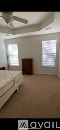 A bedroom with a bed, dresser, and window.