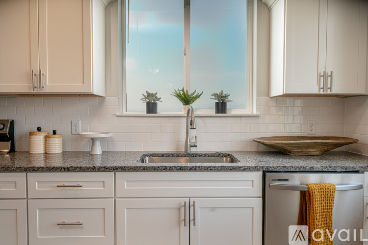 A kitchen with white cabinets and a granite countertop.