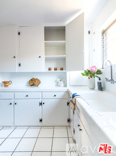A white kitchen with a sink and cabinets.