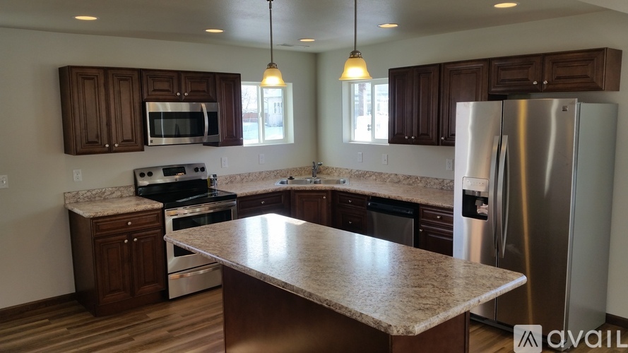 A kitchen with a granite countertop and stainless steel appliances.