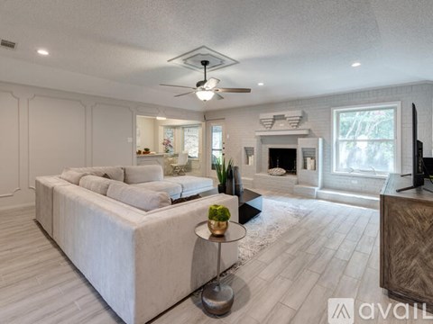 A spacious living room with a large couch and a fireplace.