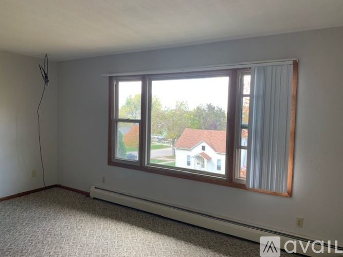 A room with a large window and a carpeted floor.