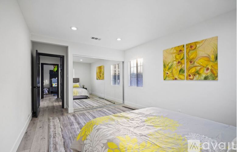 A bedroom with a bed and a painting on the wall.