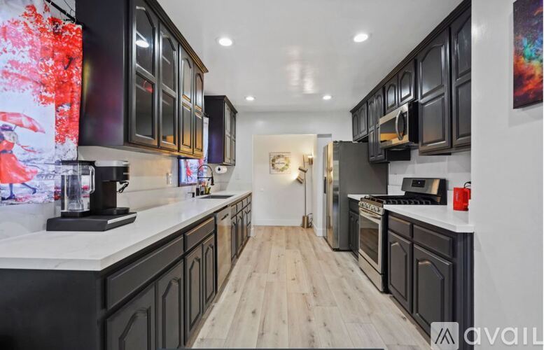 A modern kitchen with dark wood cabinets and a white countertop.