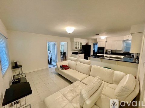 A living room with a white couch and a black coffee table.
