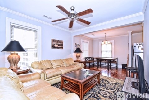 A living room with a tan couch and a wooden coffee table.