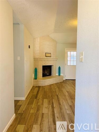 A room with a fireplace and wooden floors.
