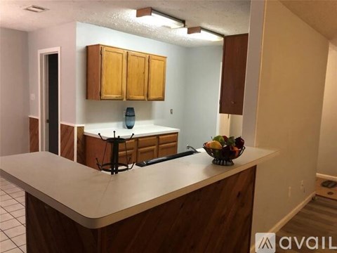 A kitchen with wooden cabinets and a white countertop.