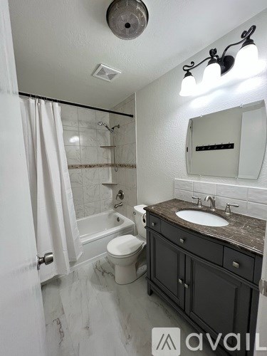 A bathroom with a toilet, sink, and shower.