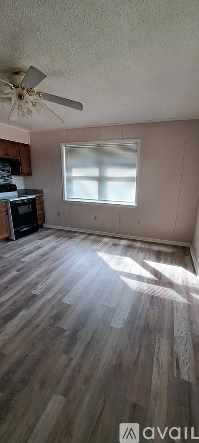 A room with wooden flooring and a ceiling fan.